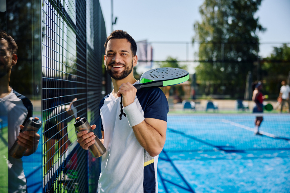 man having water break from playing tennis